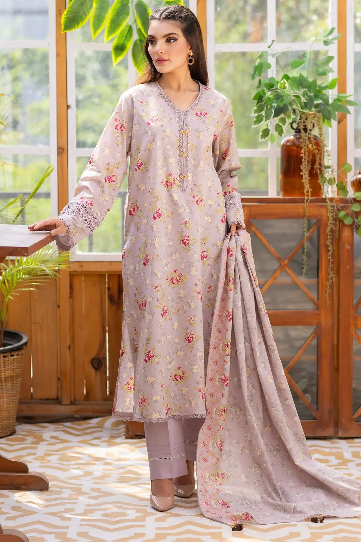 Model in a soft grey floral lawn suit and dupatta among plants